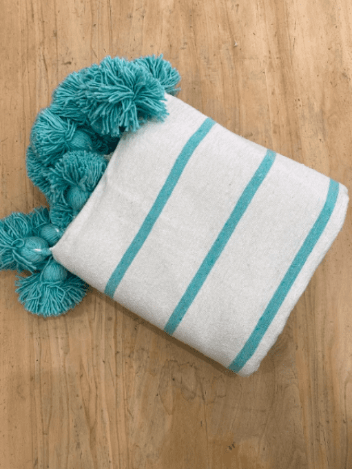 PLAID POMPONS TISSÉ BLANC ET TURQUOISE