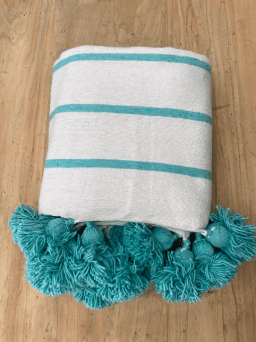 PLAID POMPONS TISSÉ BLANC ET TURQUOISE